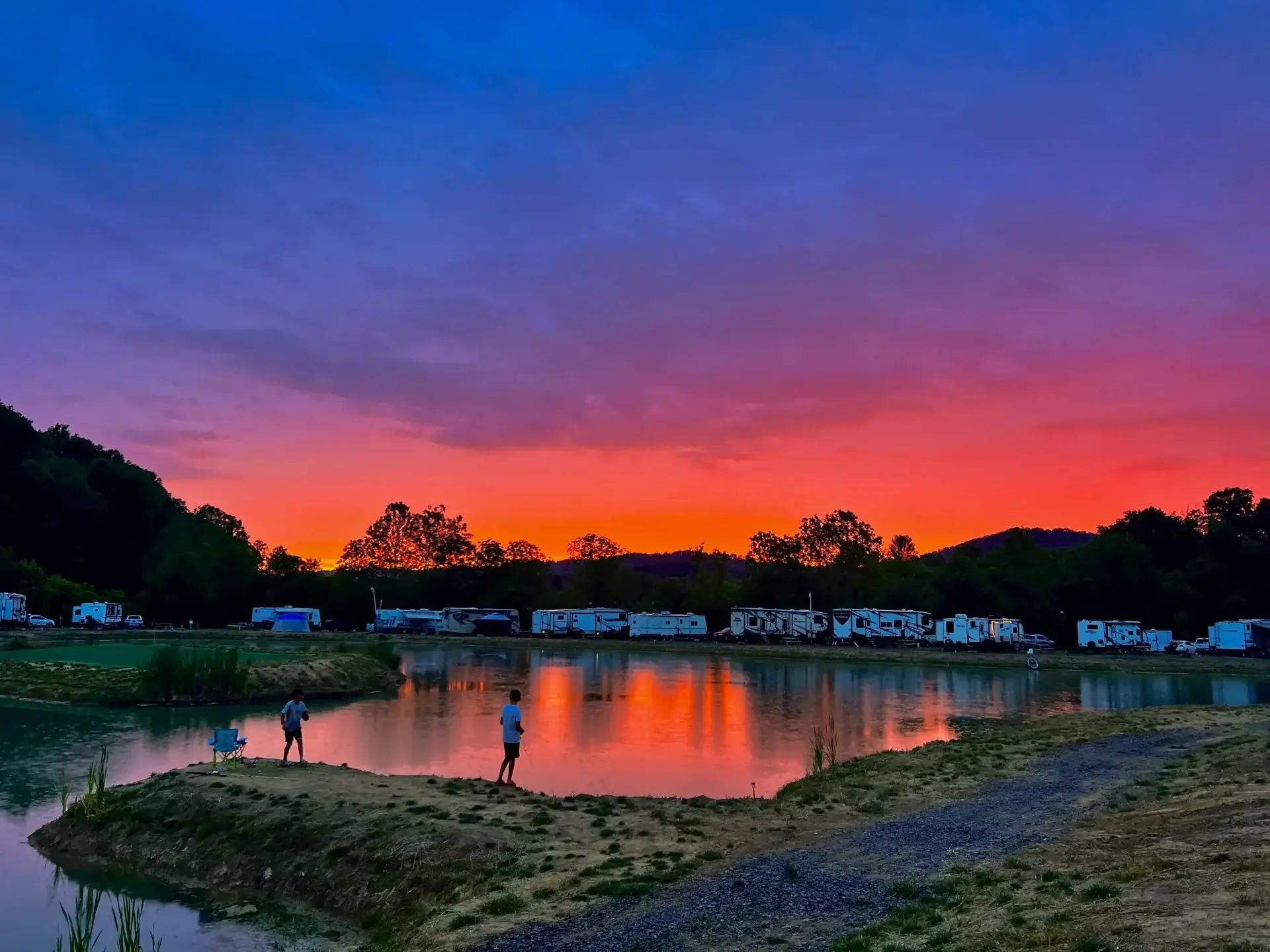 Aerial view of Mammoth Ridge RV Park with lakefront sites and Smoky Mountain sunset